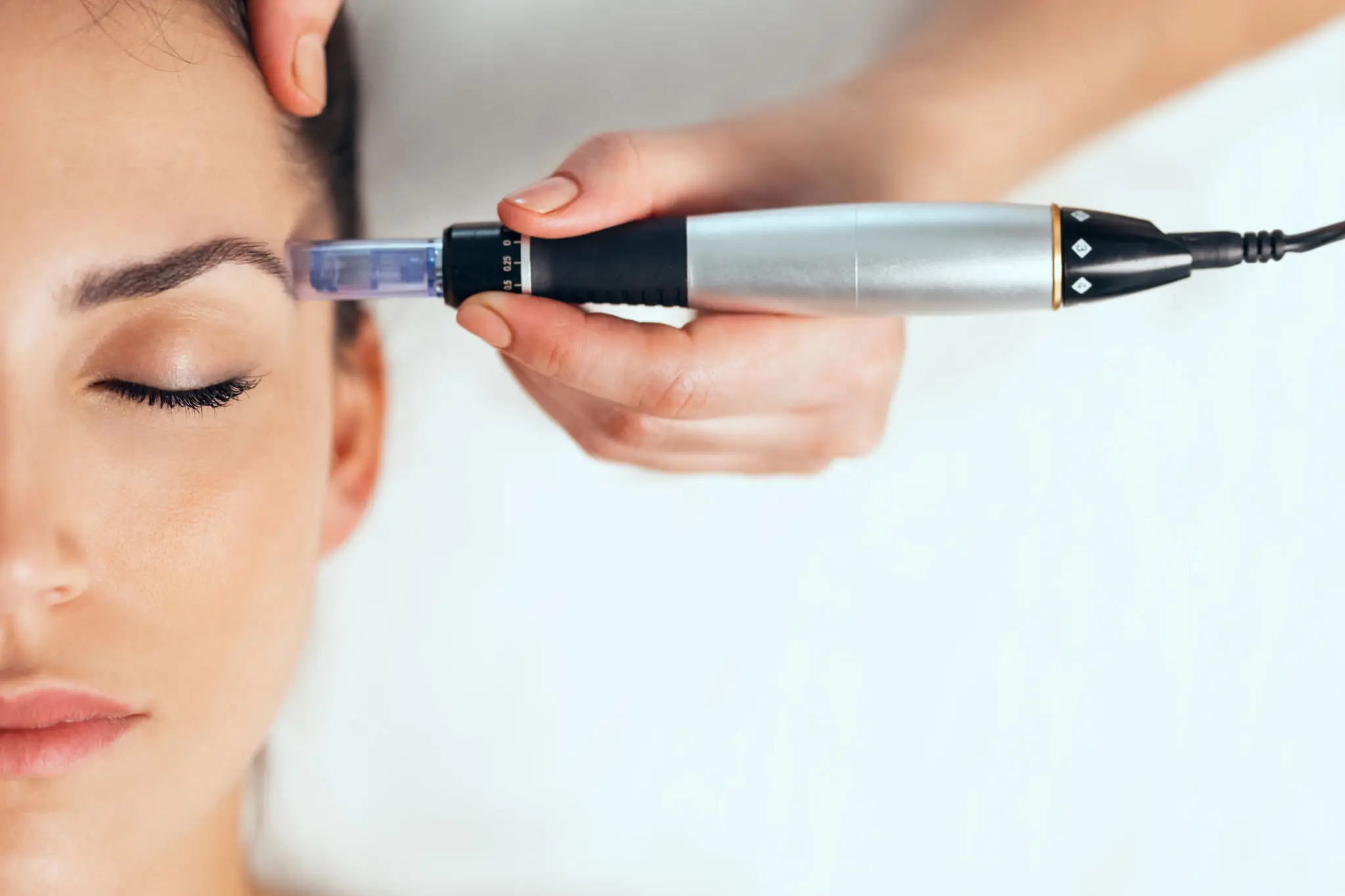 Woman receiving eyebrow microblading treatment